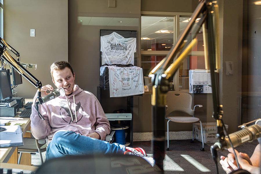 A student holds a microphone in the radio studio.