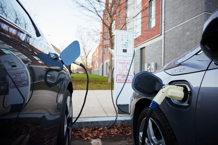 Two cars are plugged into an electric vehicle charging station.