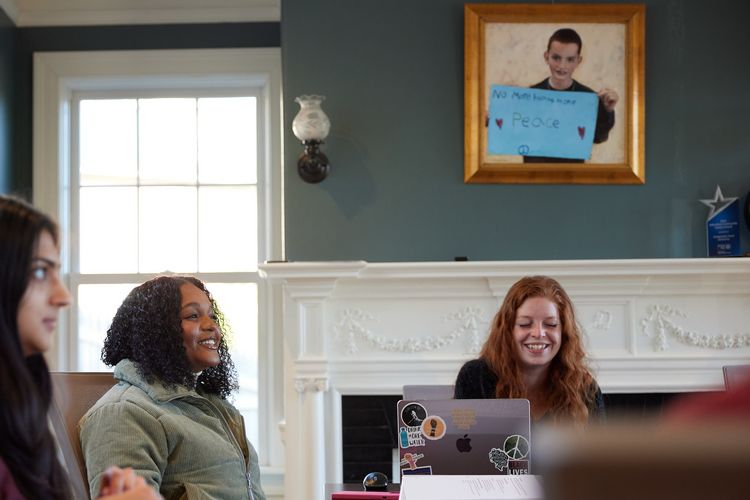 Inside the Martin Richard Institute for Social Justice, three students work at a conference table.