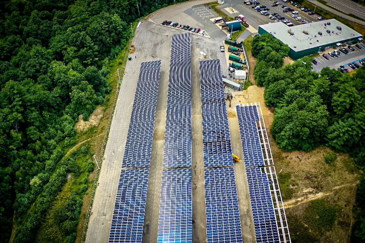 An aerial view of solar panels being installed above a parking lot.