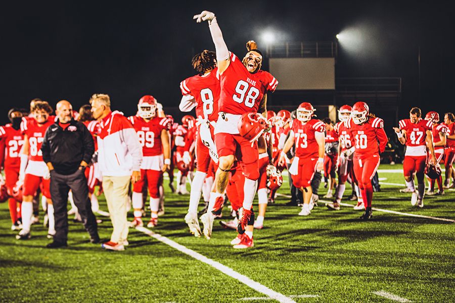    A group of BSU football players celebrate on the field.