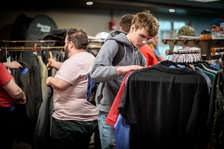 Students browse racks of business clothing during a campus event.