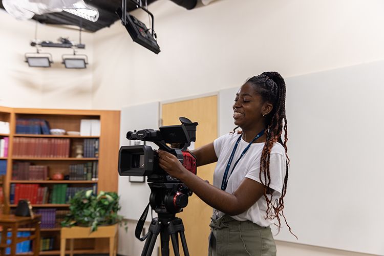 A student uses a camera on a tripod at an internship.