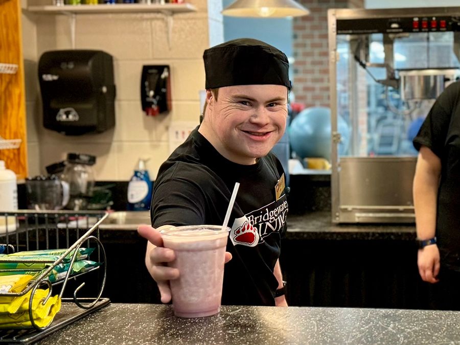 An EXCEL student places a smoothie on a counter.