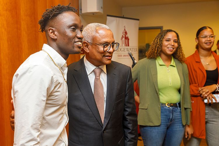 The president of Cabo Verde poses for a photo with three students.